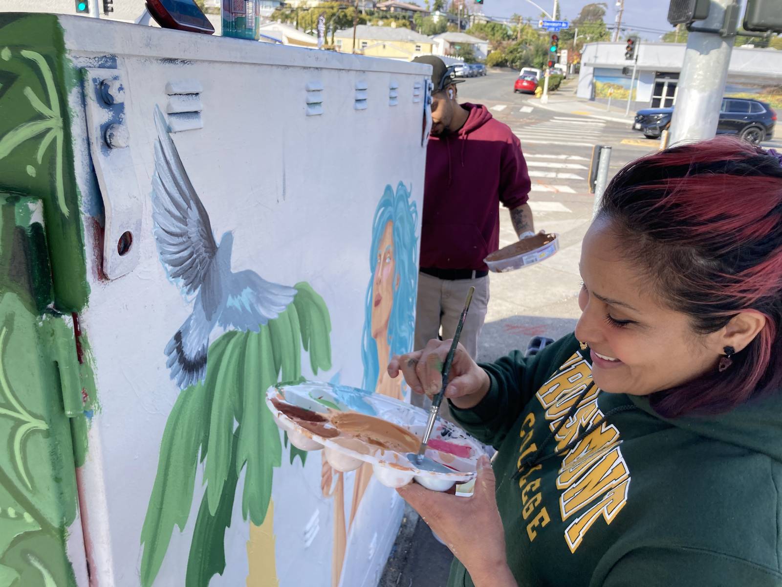 Student painting a colorful mural at Grossmont College