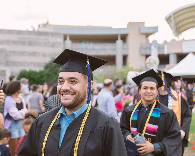 Graduates in cap and gown celebrating at commencement