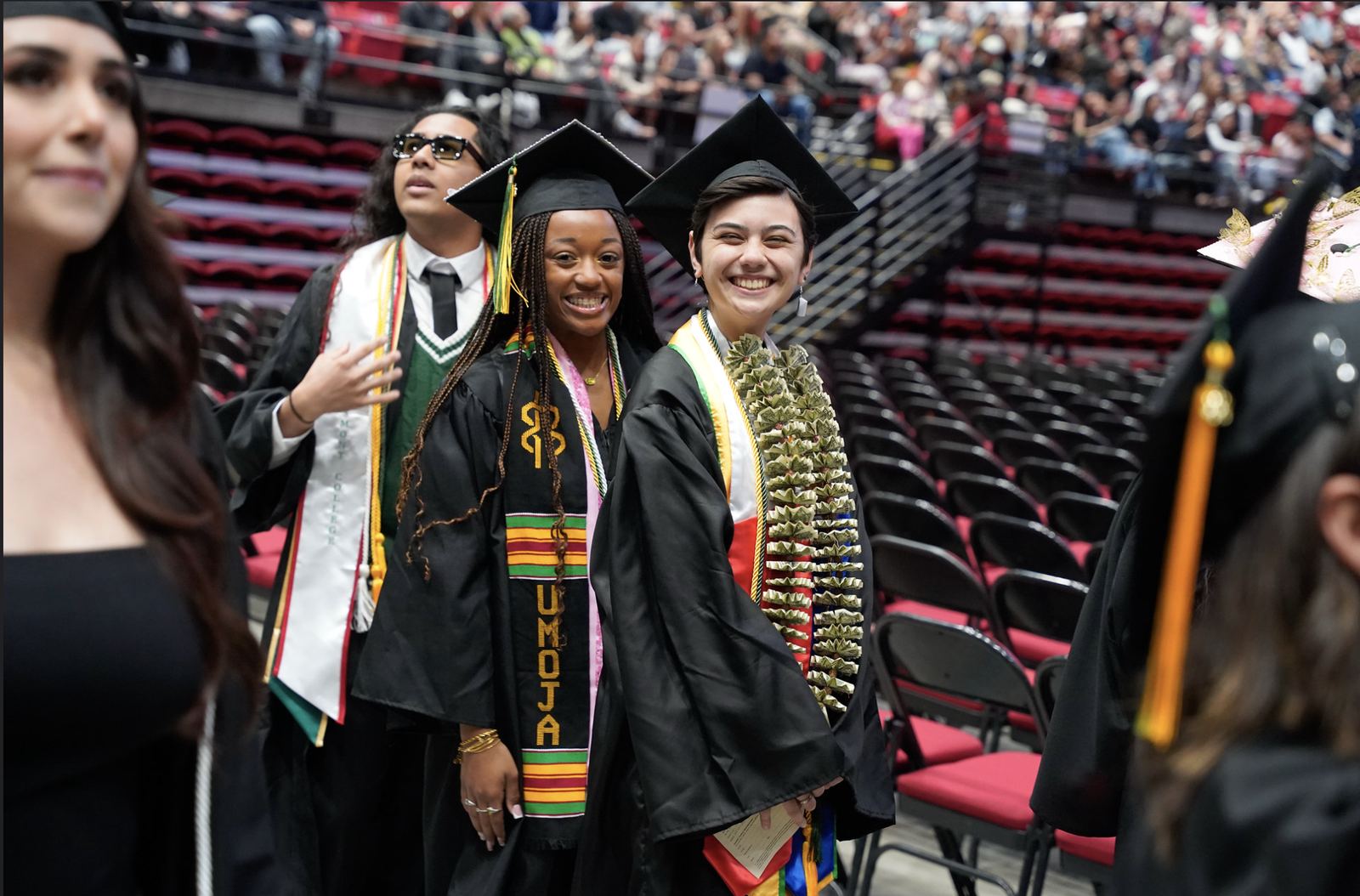 Cuyamaca and Grossmont graduates celebrating at commencement with regalia and leis